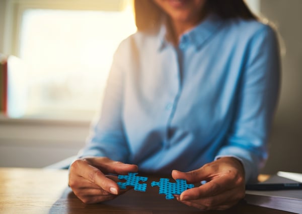 business-woman-connecting-puzzles-PAQ2WWZ